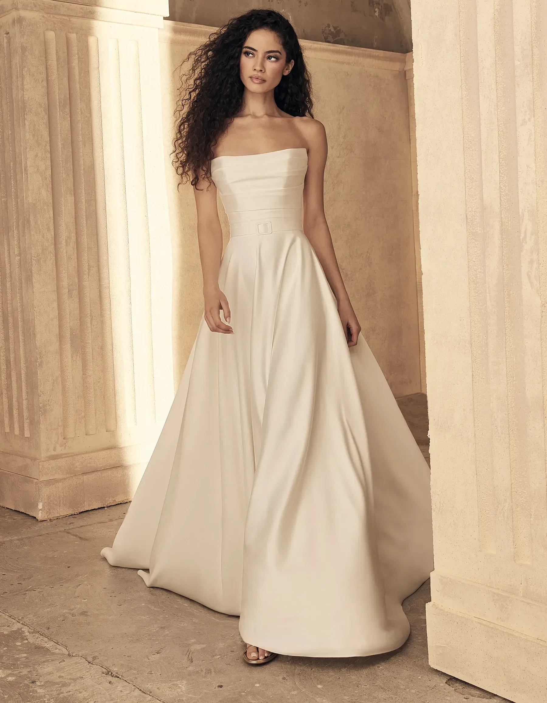 Model wearing a white gown from Paloma Blanca Fall 2024