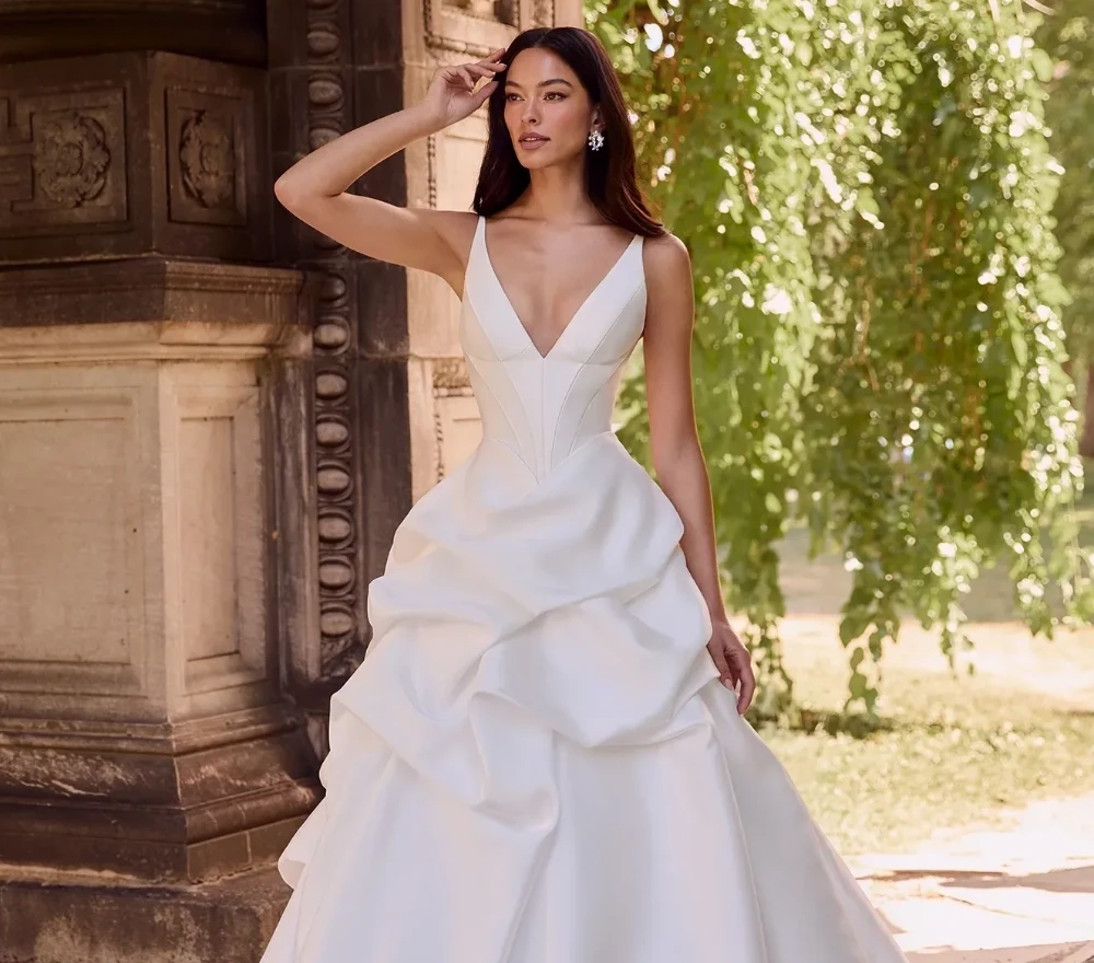 Model wearing a white gown from Paloma Blanca Fall 2024